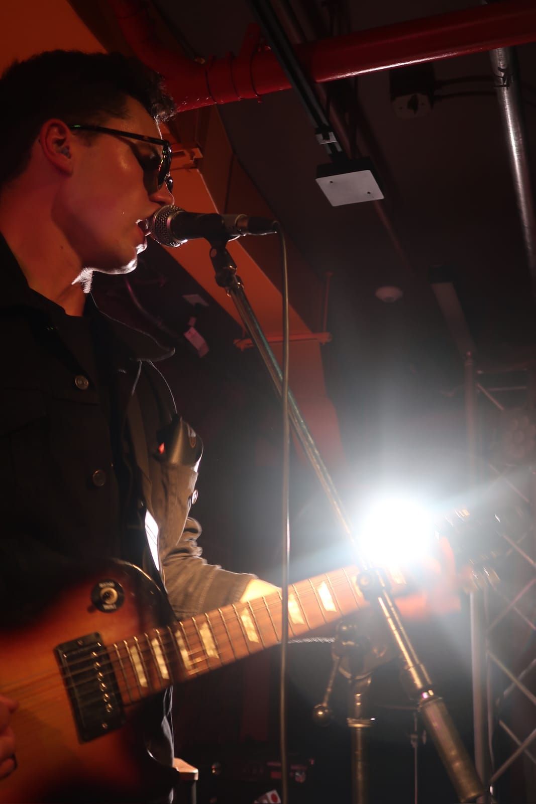The Vagrancy frontman singing into the mic, close up